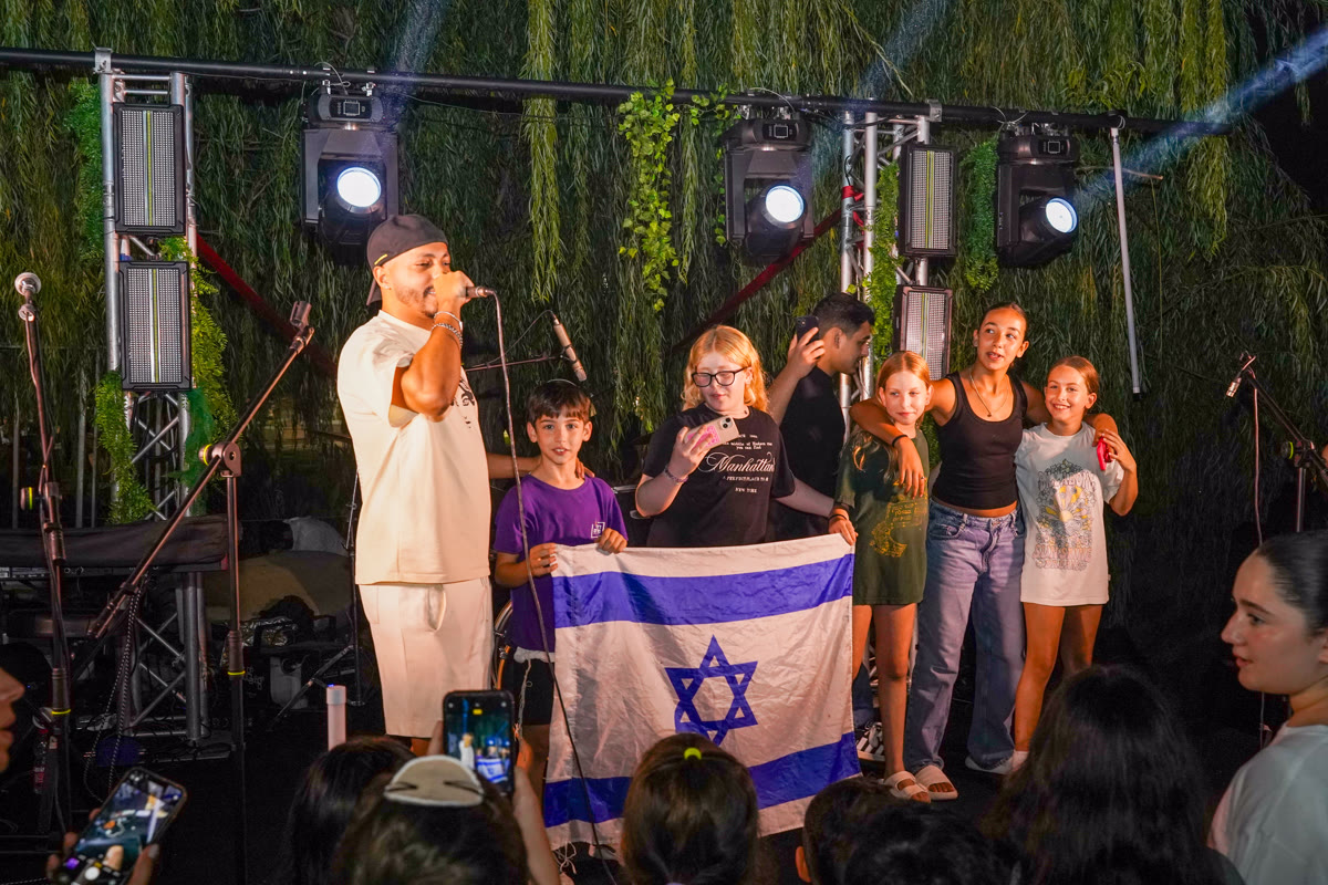 מאור גמליאל על הבמה עם ילדים שמחזיקים דגל ישראל